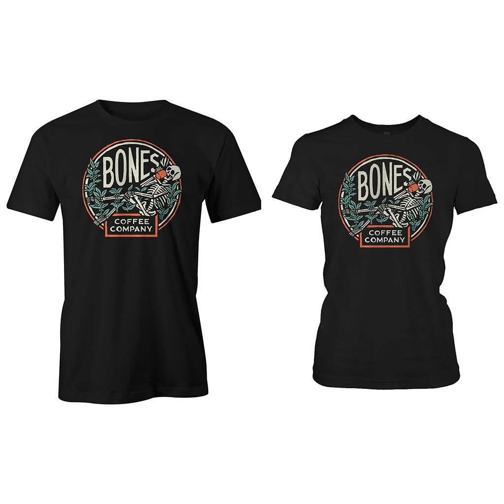 The men's and women's classic Bones Coffee Company logo tee shirt. The tee shirt is black and the logo has a skeleton sipping coffee resting on greenery.