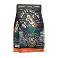 The front of a 12 ounce bag of Bones Coffee Company Salty Siren coffee. Its flavor is sea salted caramel mocha, and it has a skeleton dressed up as a sailor holding a mermaid on the art.